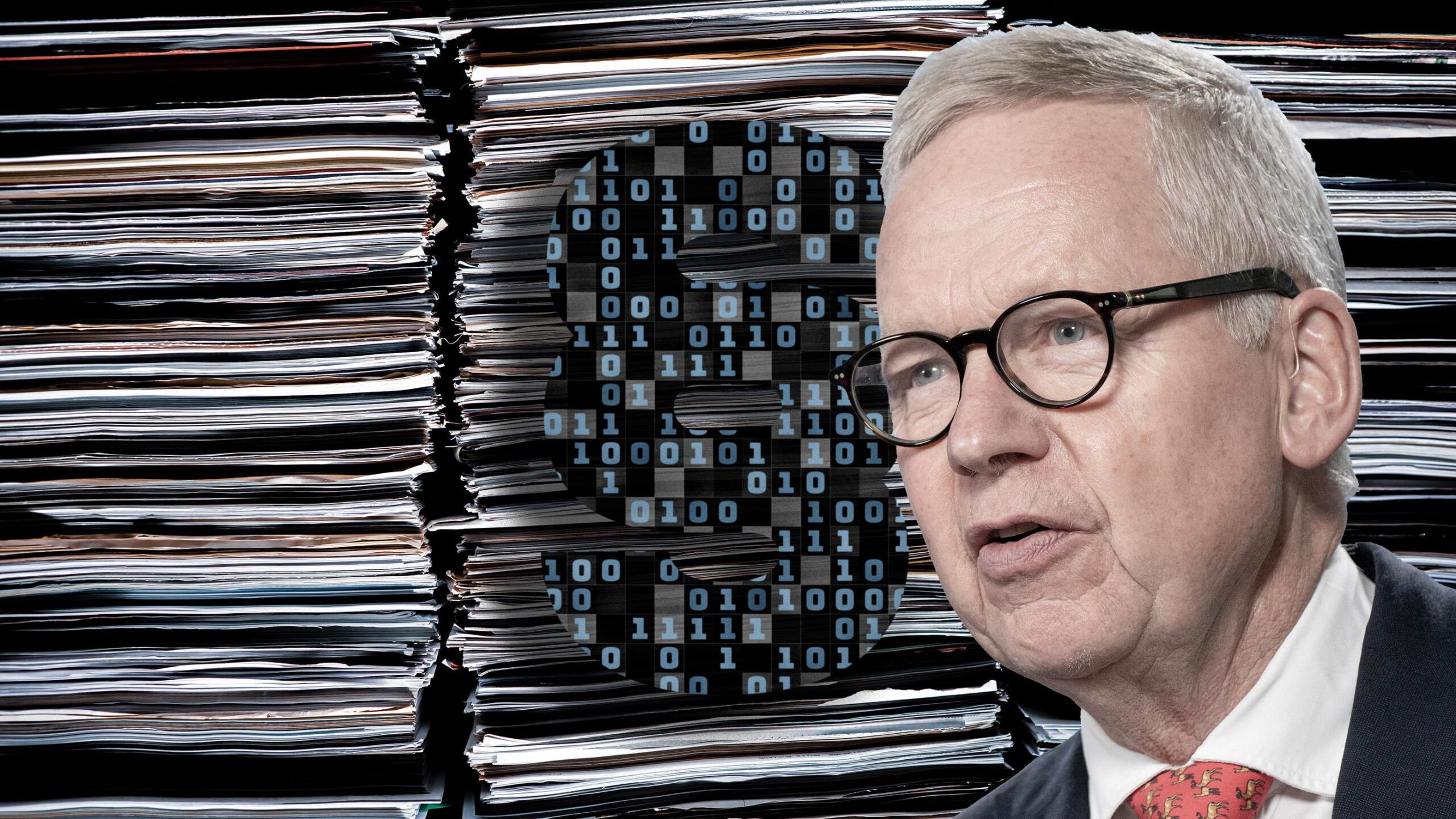 Lutz Goebel, Vorsitzender des Normenkontrollrats vor Aktenstapeln und Paragraphen-Zeichen