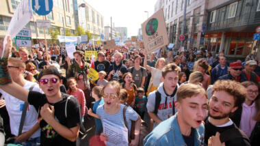 Jugendliche Demonstrant:innen mit Klimaschildern