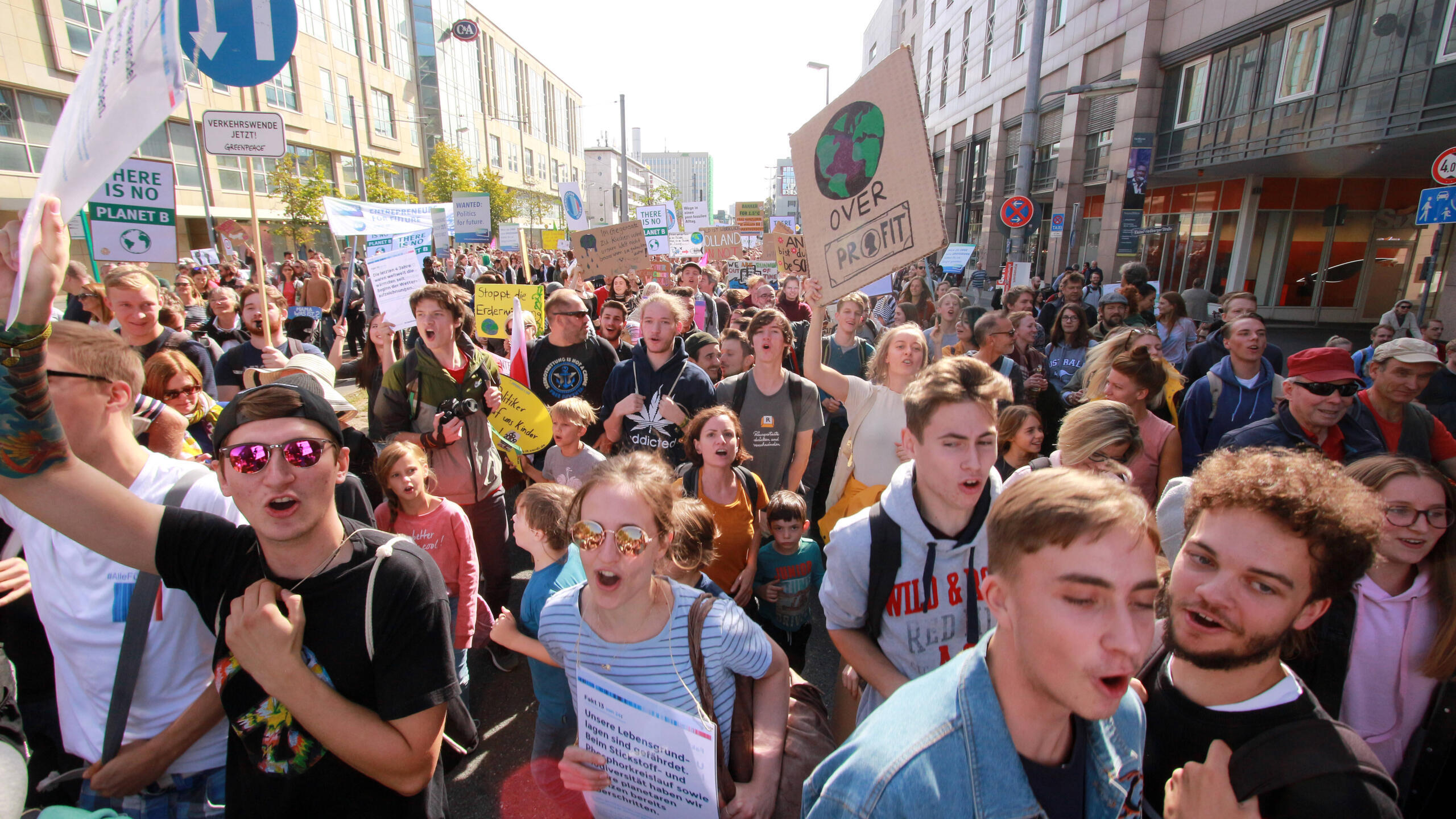Jugendliche Demonstrant:innen mit Klimaschildern