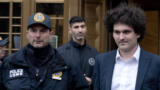 Der FTX-Gründer Sam Bankman-Fried neben einem Polizisten am 3. Januar 2023 in New York City auf dem zur Gerichtsverhandlung