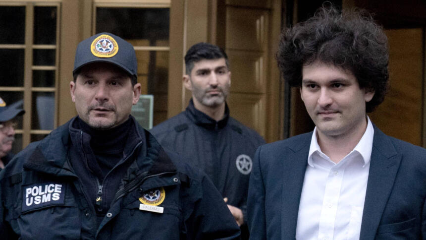 Der FTX-Gründer Sam Bankman-Fried neben einem Polizisten am 3. Januar 2023 in New York City auf dem zur Gerichtsverhandlung