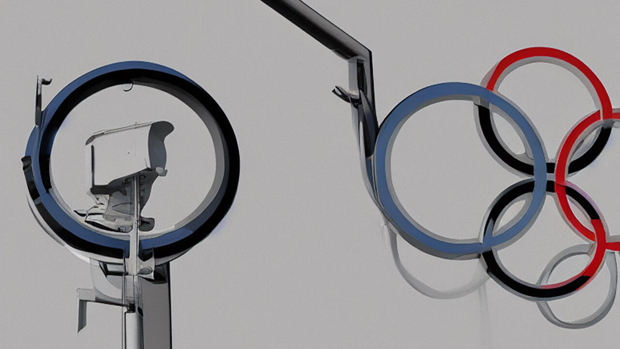 Eine Überwachungskamera schaut auf abstrahierte Olympische Ringe.