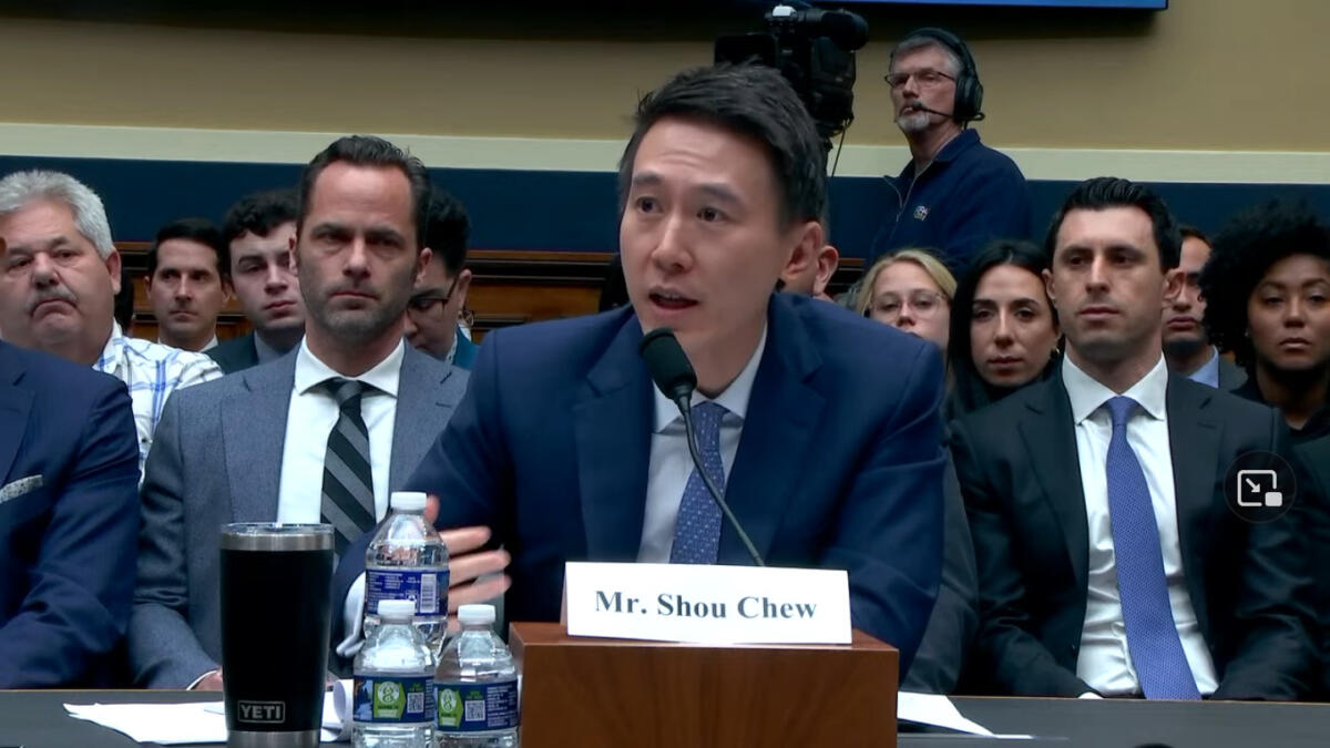 CEO Shou Chew sitzt an einem Holztisch vor dem Kongress, hinter ihm Publikum