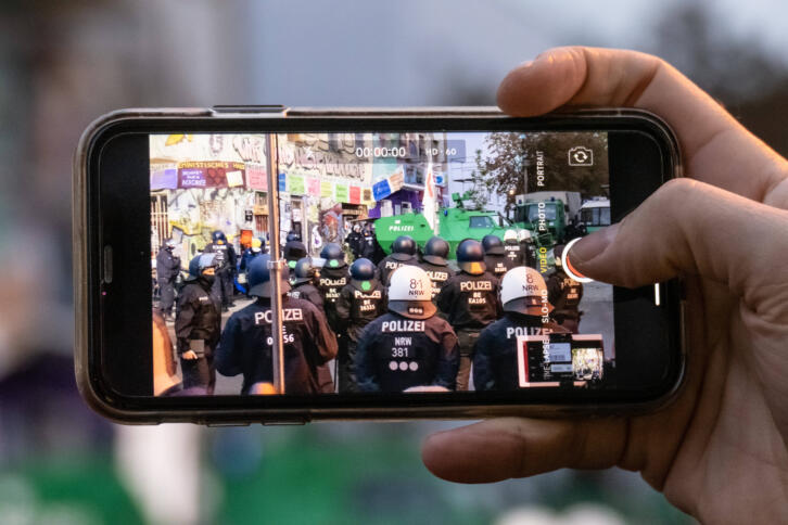 Smartphone mit Polizisten auf dem Display.