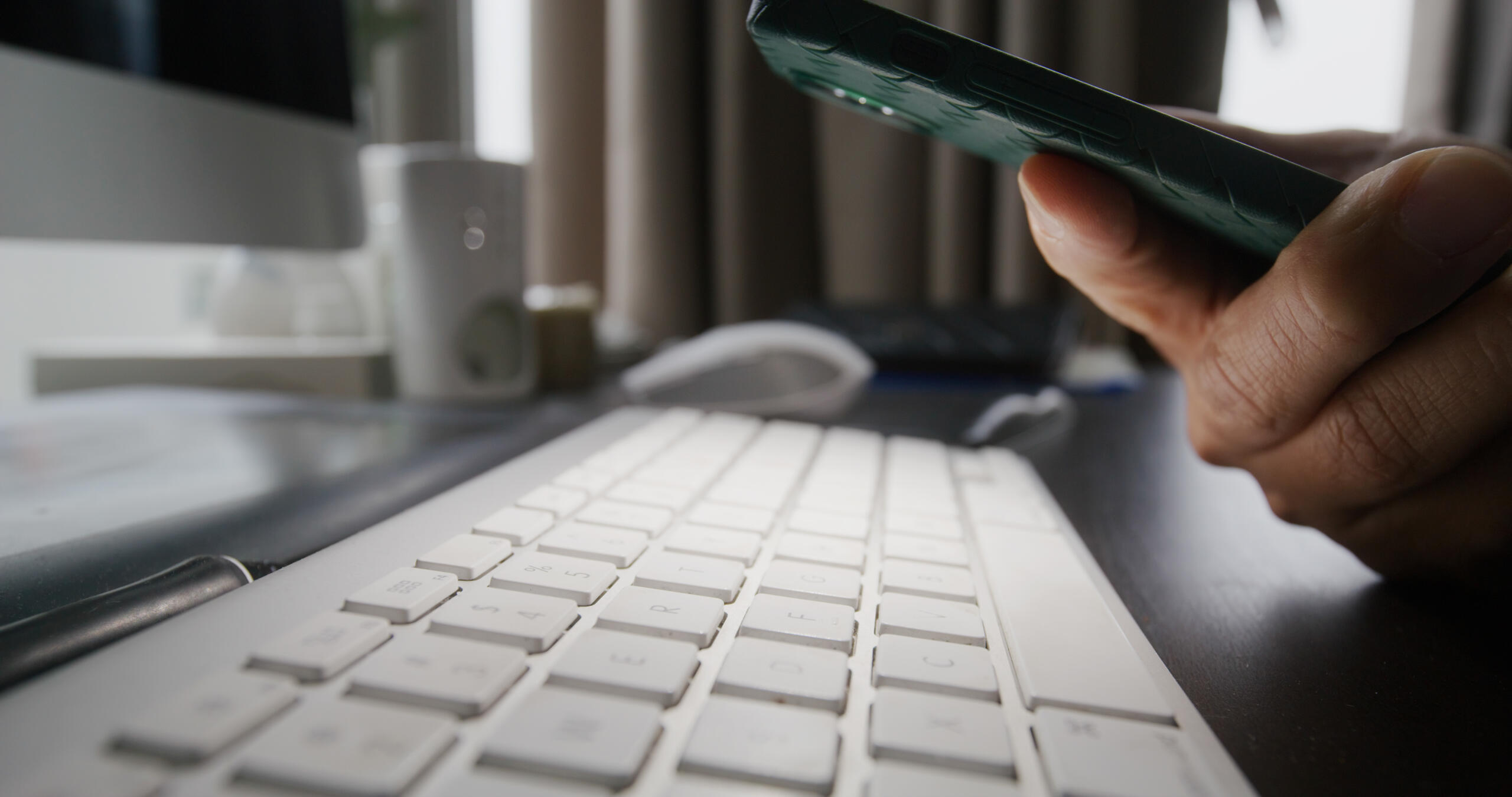 Mann benutzt Handy-Taschenlampe zur Überprüfung einer Tastatur