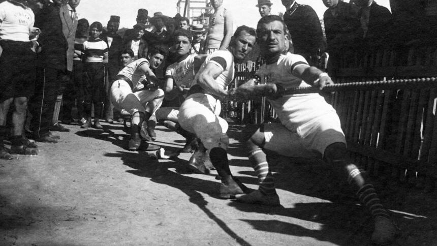 Männer ziehen auf einem schwarz-weiß Bild aus den den Dreißiger Jahren an einem Seil.