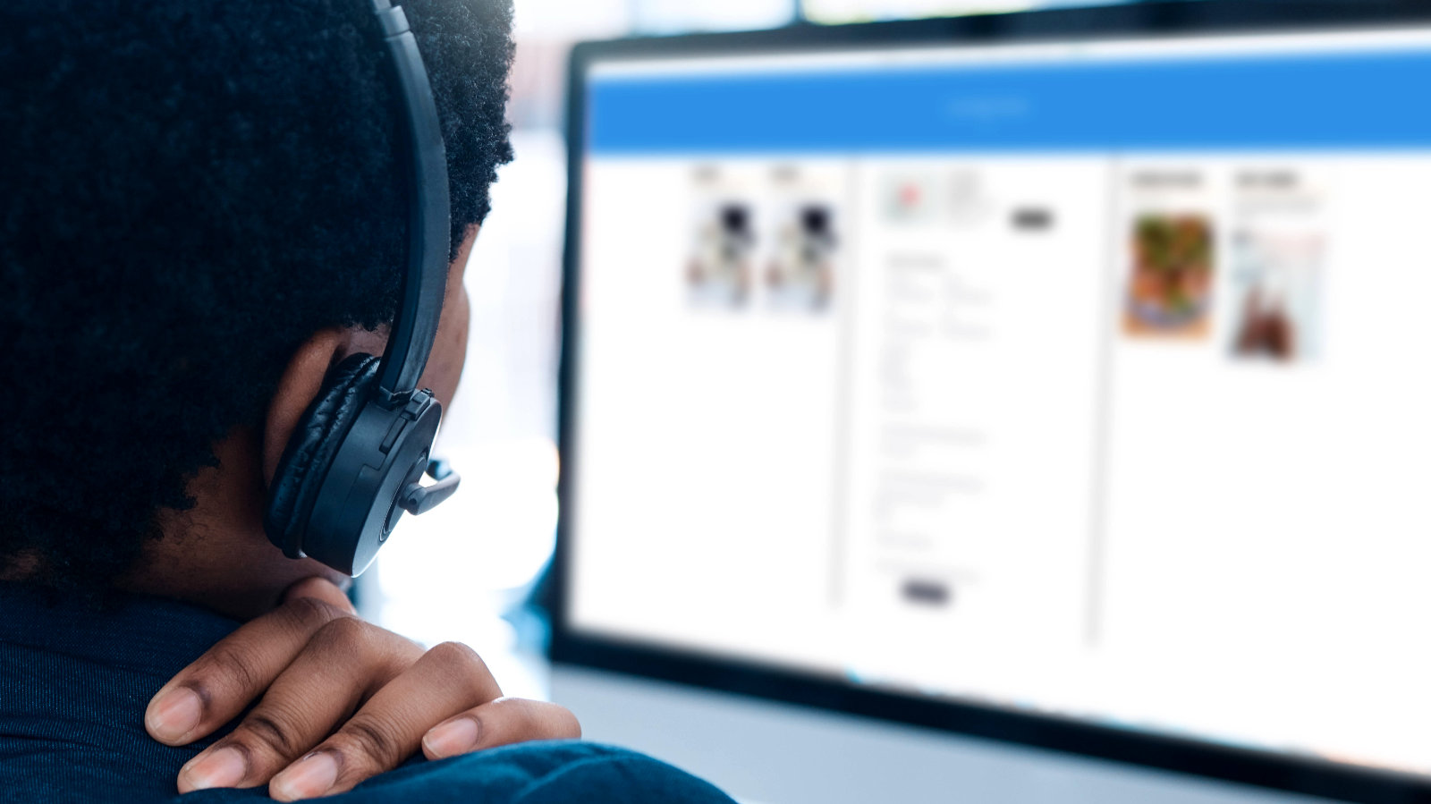 Eine Person mit einem Headset vor einem Computerbildschirm