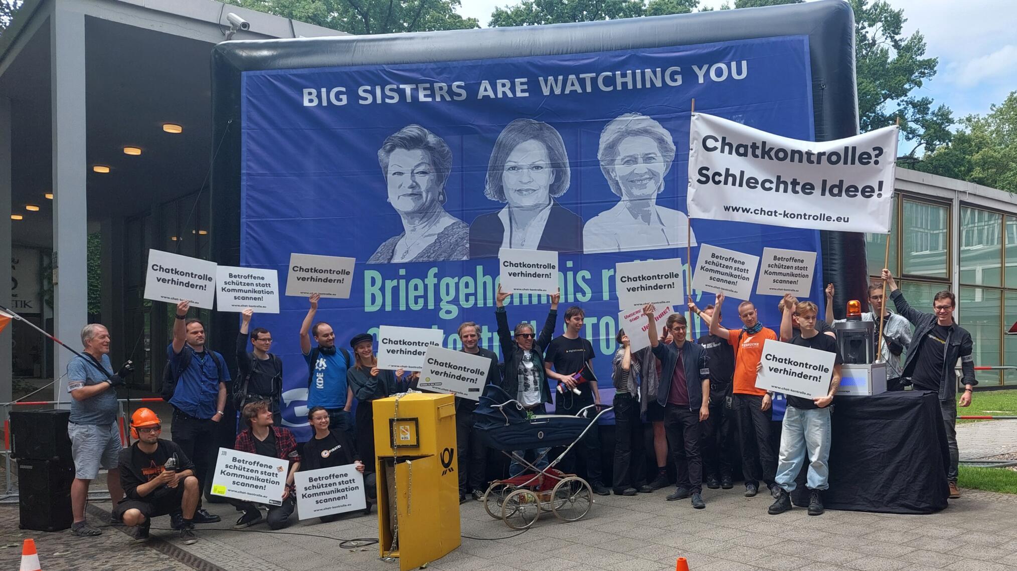 Demonstrierende stehen vor einem Banner