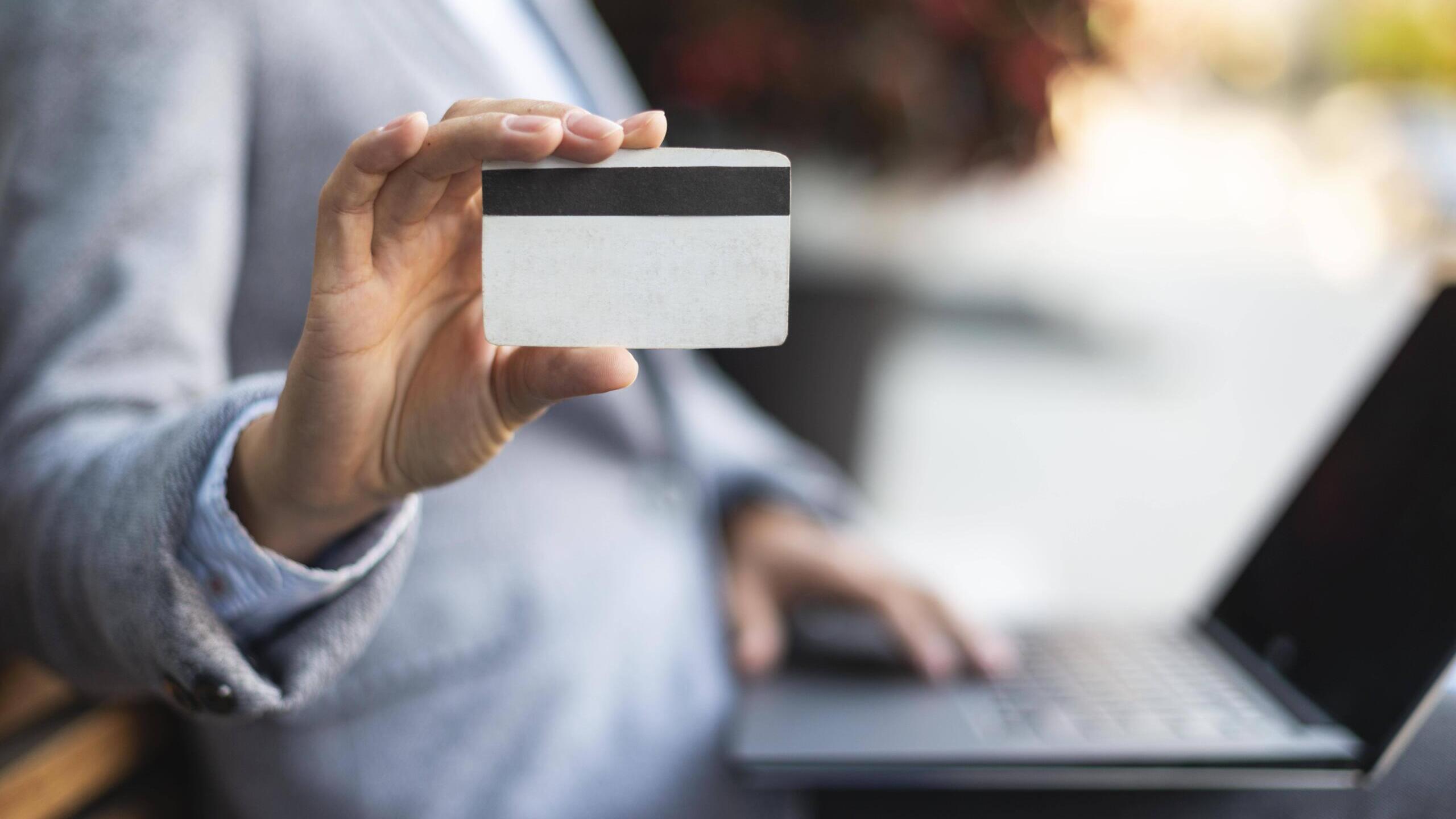 Mensch hält Kreditkarte in Kamera