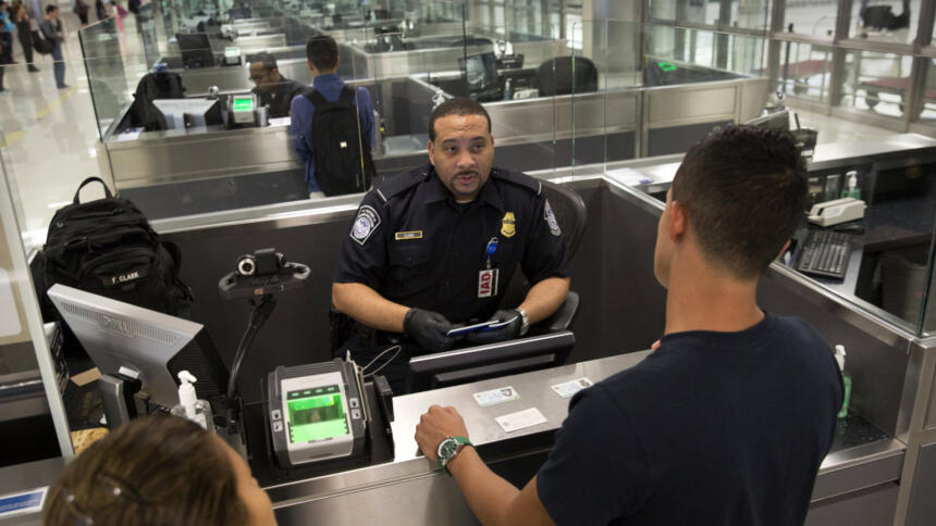 Ein Beamter der US-Zoll- und Grenzschutzbehörde kontrolliert internationale Passagiere Dulles International Airport in Dulles, Virginia.