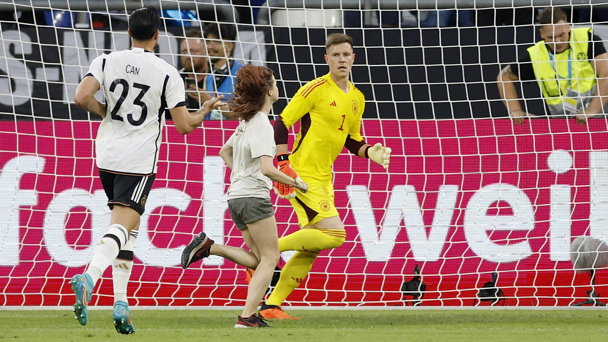 Eine Klimaaktivistin rennt beim Länderspiel aus Protest über den Platz.