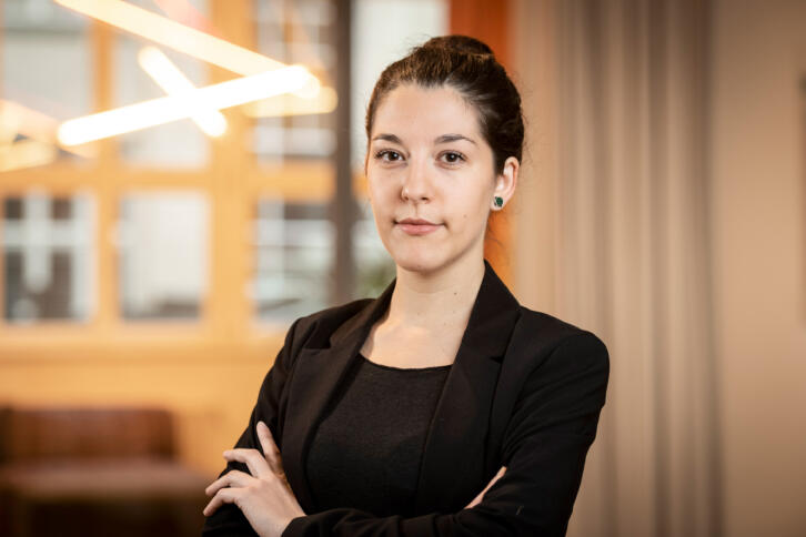 Portrait of person in black blazer with crossed arms