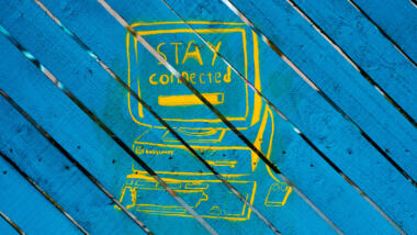 Ein gelbes Graffiti auf blauem Grund, das den Aufruf "Stay connected"