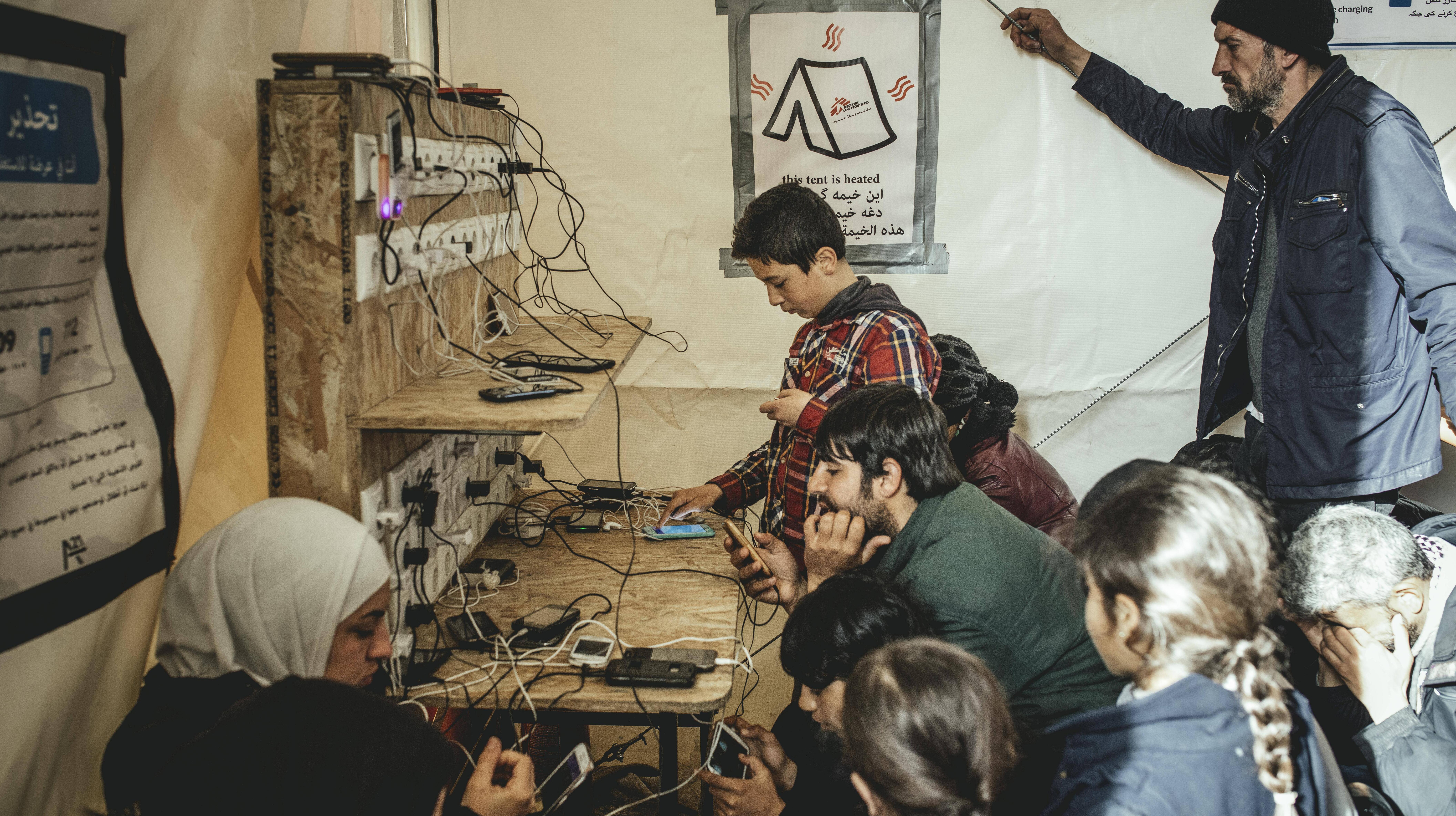 Menschen an einer Handyladestation in Idomeni