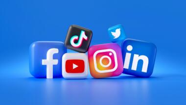 Blauer Hintergrund, davor dreidimensionale Würfel mit den Logos von Facebook, Youtube, Tiktok, Instagram, Twitter und LinkedIn