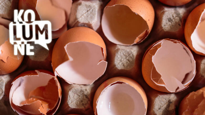 Zerbrochene Eier in einem Eierkarton, von oben fotografiert