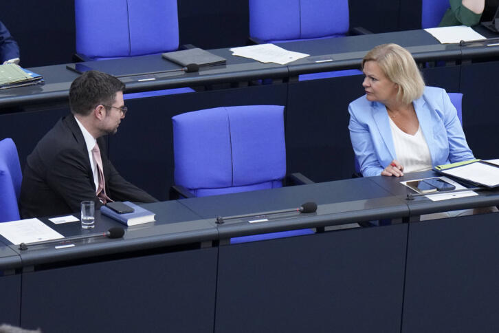Marco Buschmann und Nancy Faeser im Bundestag. Zwischen ihnen ist ein Stuhl frei.