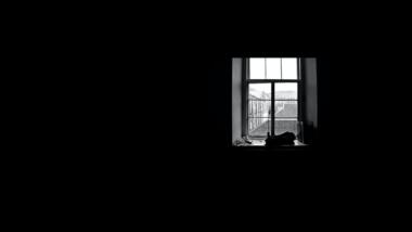 schwarz-weiß Bild eines Fensters in einer schwarzen Wand