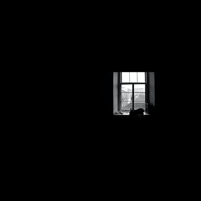 schwarz-weiß Bild eines Fensters in einer schwarzen Wand