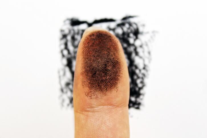 Ein Finger mit schwarzer Fingerabdrucktinte