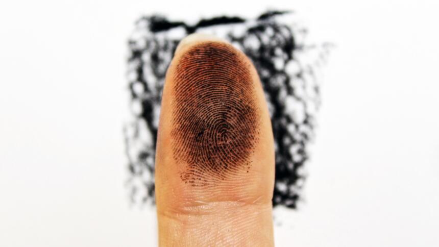 Ein Finger mit schwarzer Fingerabdrucktinte