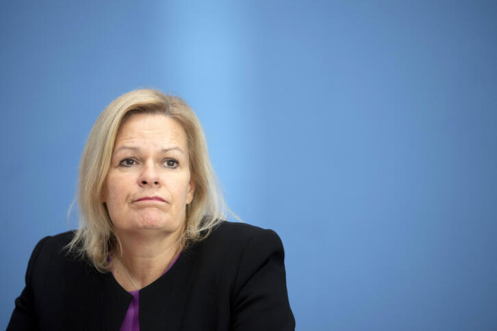 Eine blonde Fraue vor blauer Wand