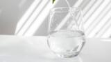 Ein Trinkglas, das etwa zur Hälfte mit Wasser gefüllt ist