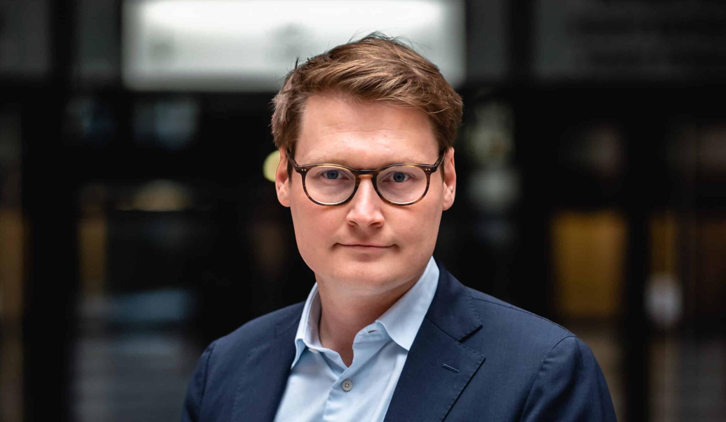 Moritz Körner, in Hemd und Anzug, schaut in die Kamera.