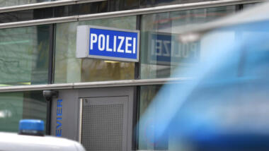 Das Bild zeigt das blaue "Polizei"-Schild an der Fassade des Polizeireviers in Frankfurt am Main.
