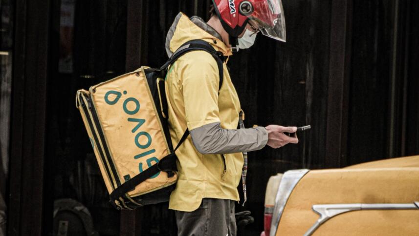 Ein Glovo-Fahrer schaut auf sein Handy
