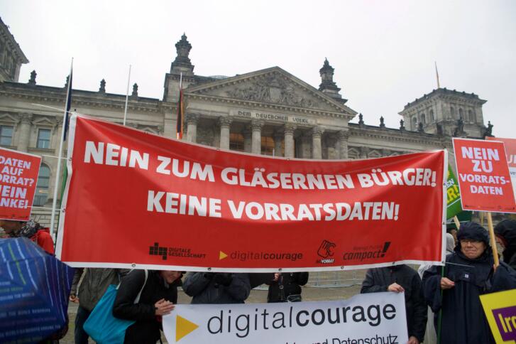 Eine Demonstration vor dem Deutschen Bundestag. Auf einem Roten Banner steht in weiß: "Nein zum gläsernen Bürger! Keine Vorratsdaten"
