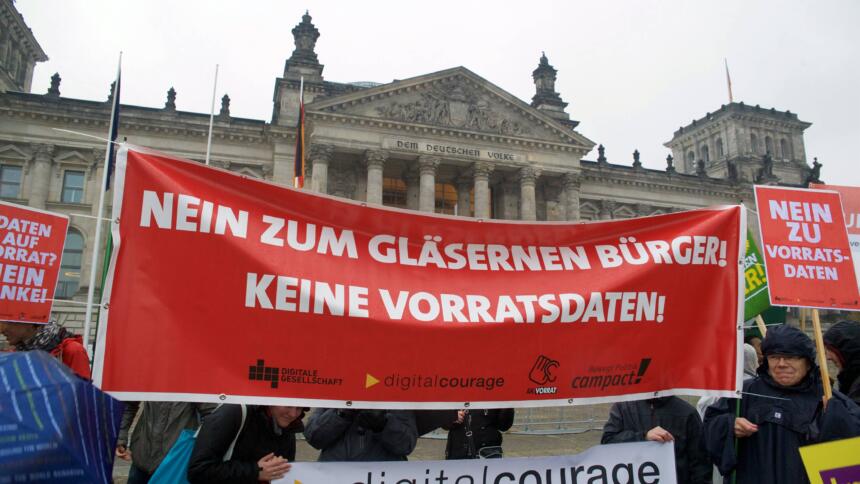 Eine Demonstration vor dem Deutschen Bundestag. Auf einem Roten Banner steht in weiß: "Nein zum gläsernen Bürger! Keine Vorratsdaten"