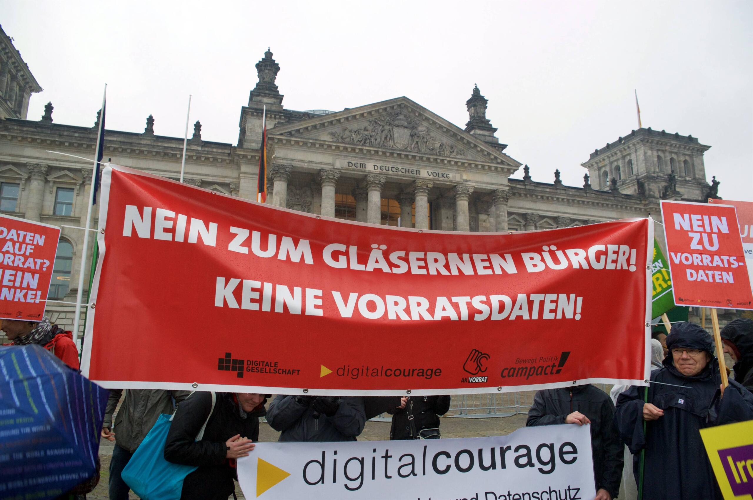 Eine Demonstration vor dem Deutschen Bundestag. Auf einem Roten Banner steht in weiß: "Nein zum gläsernen Bürger! Keine Vorratsdaten"