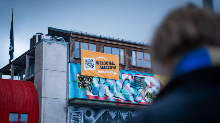 Plakat auf einem Haus mit der Aufschrift. Welcome Amazon. Ähmazon.de