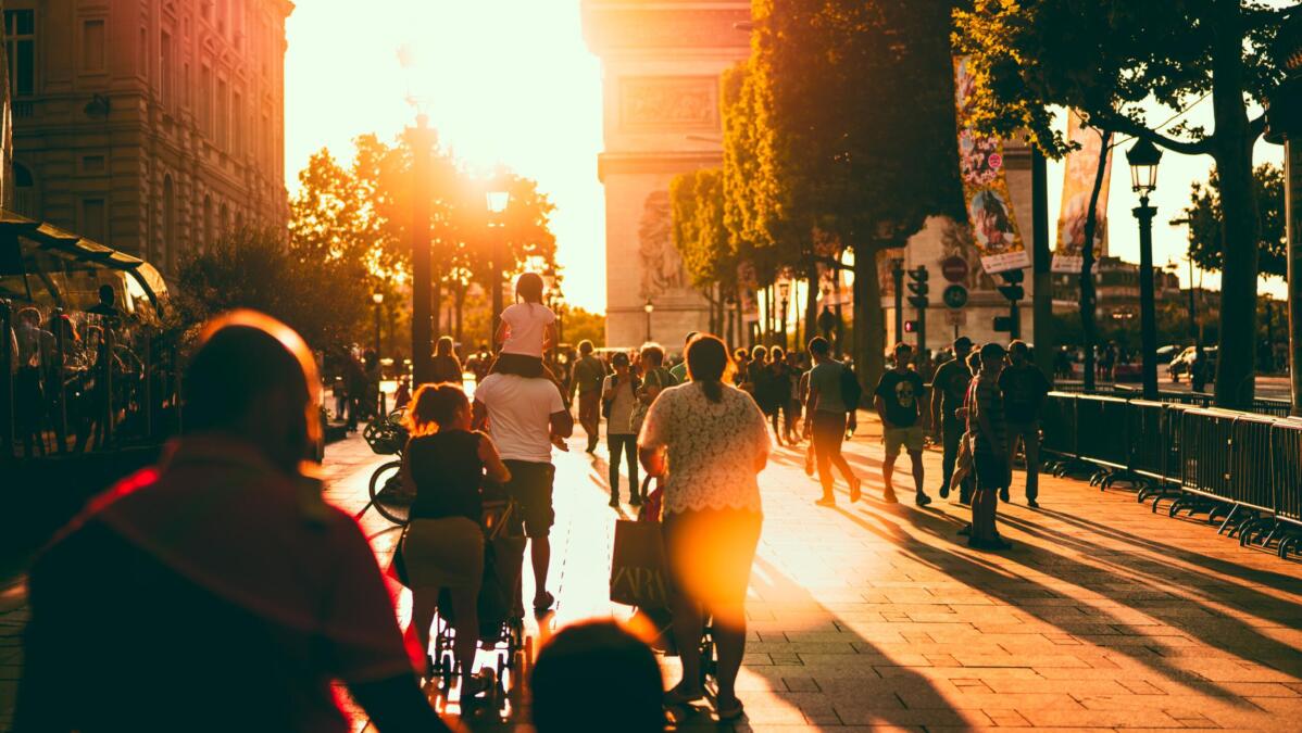 Passant:innen vor dem Arc de Triomph in Frankreich bei Sonnenuntergang