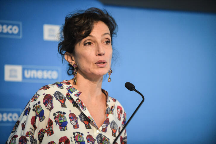 Eine Frau mit dunklel Haaren hält eine Rede