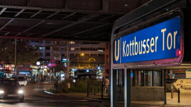 Das Kottbusser Tor bei Nacht: Im Hintergrund sieht man die Nebenwache der Polizei Berlin.