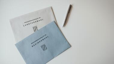Zwei Umschläge für Briefwahlen mit der Aufschrift "Landtagswahl" und "Bezirkswahl".