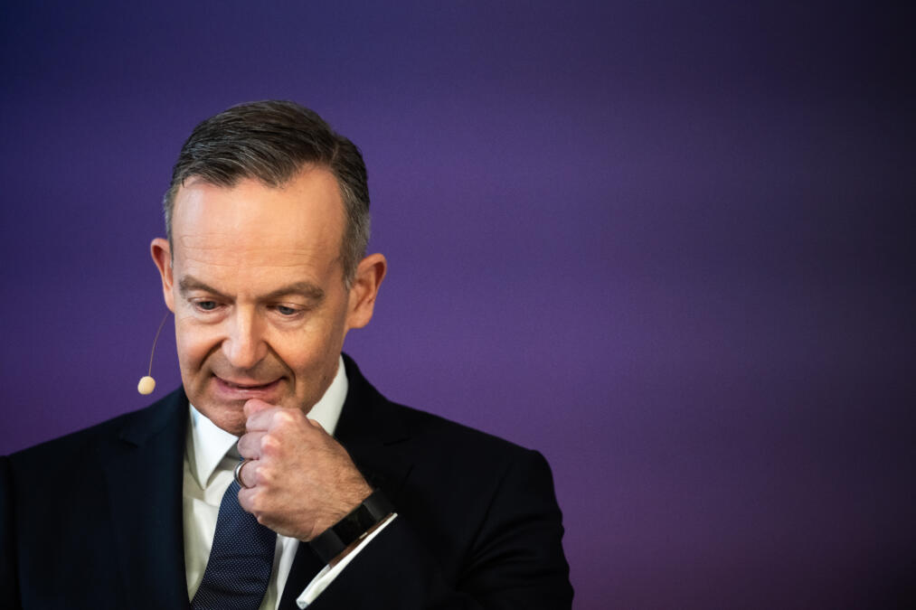 Mann im schwarzen Anzug mit Headset schaut nach unten