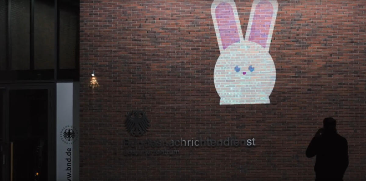 Projektion eines Comic-Hasen auf die Fassade des BND im Dunkeln