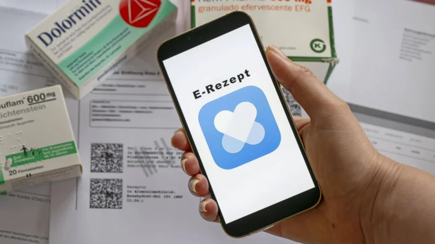 E-Rezept mittels gleichnamiger Handy-App, im Hintergrund Ibuprofen- und Dolormin-Tabletten