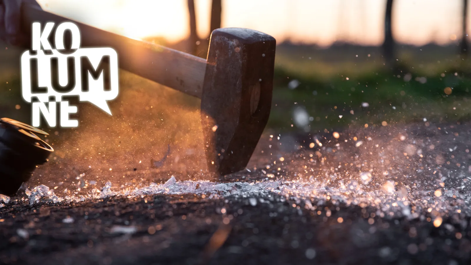 Ein Hammer, der auf Straßenasphalt auftrifft und Glas zerschlägt