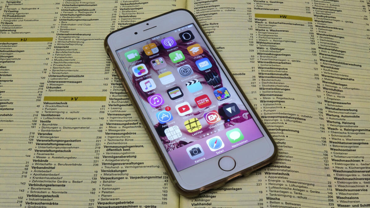Ein Smartphone liegt auf einem aufgeschlagenen Telefonbuch