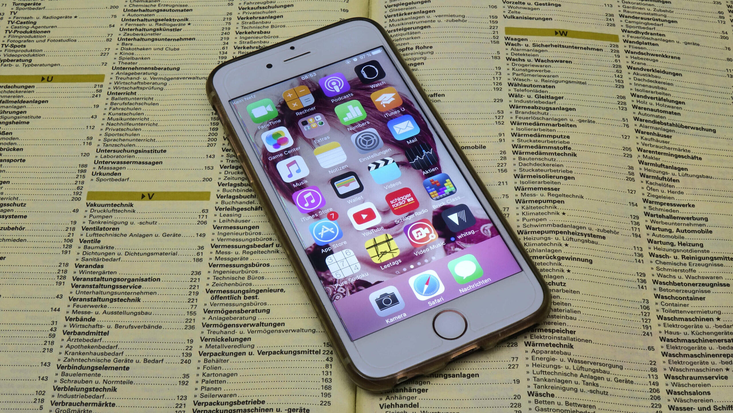 Ein Smartphone liegt auf einem aufgeschlagenen Telefonbuch