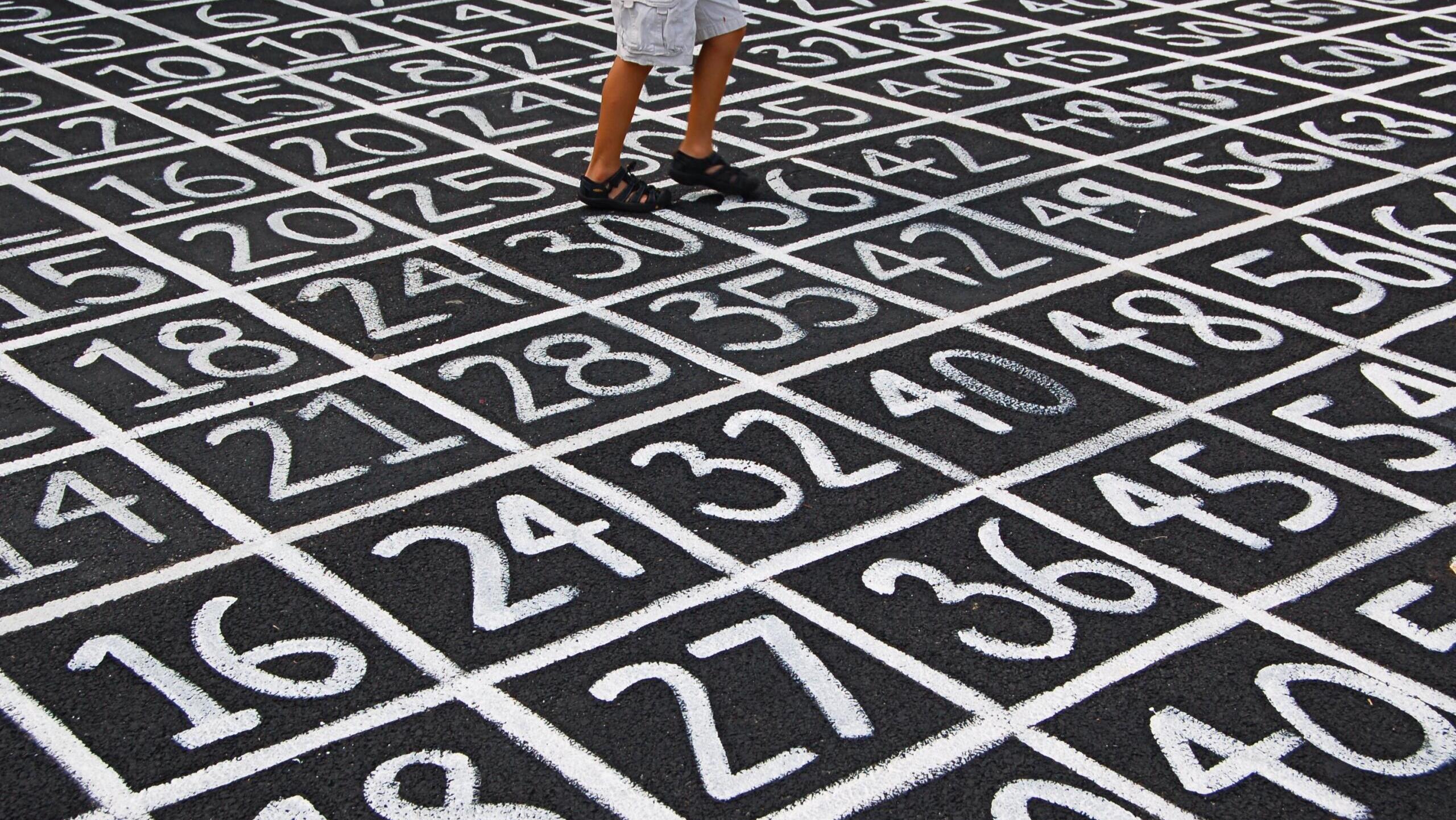 Verschiedene Zahlen sind in weiß auf Asphalt gemalt