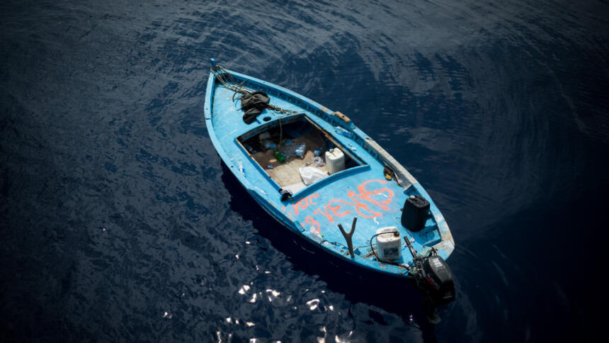 Ein hellblaues Holzboot auf dem Meer
