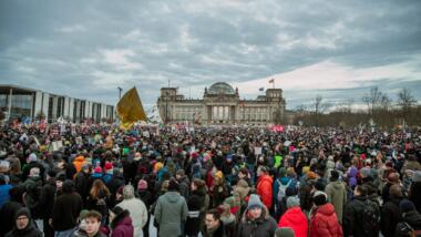 Große Menschenmenge steht vor dem Reichstag in Berlin.