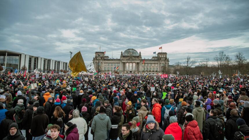Große Menschenmenge steht vor dem Reichstag in Berlin.