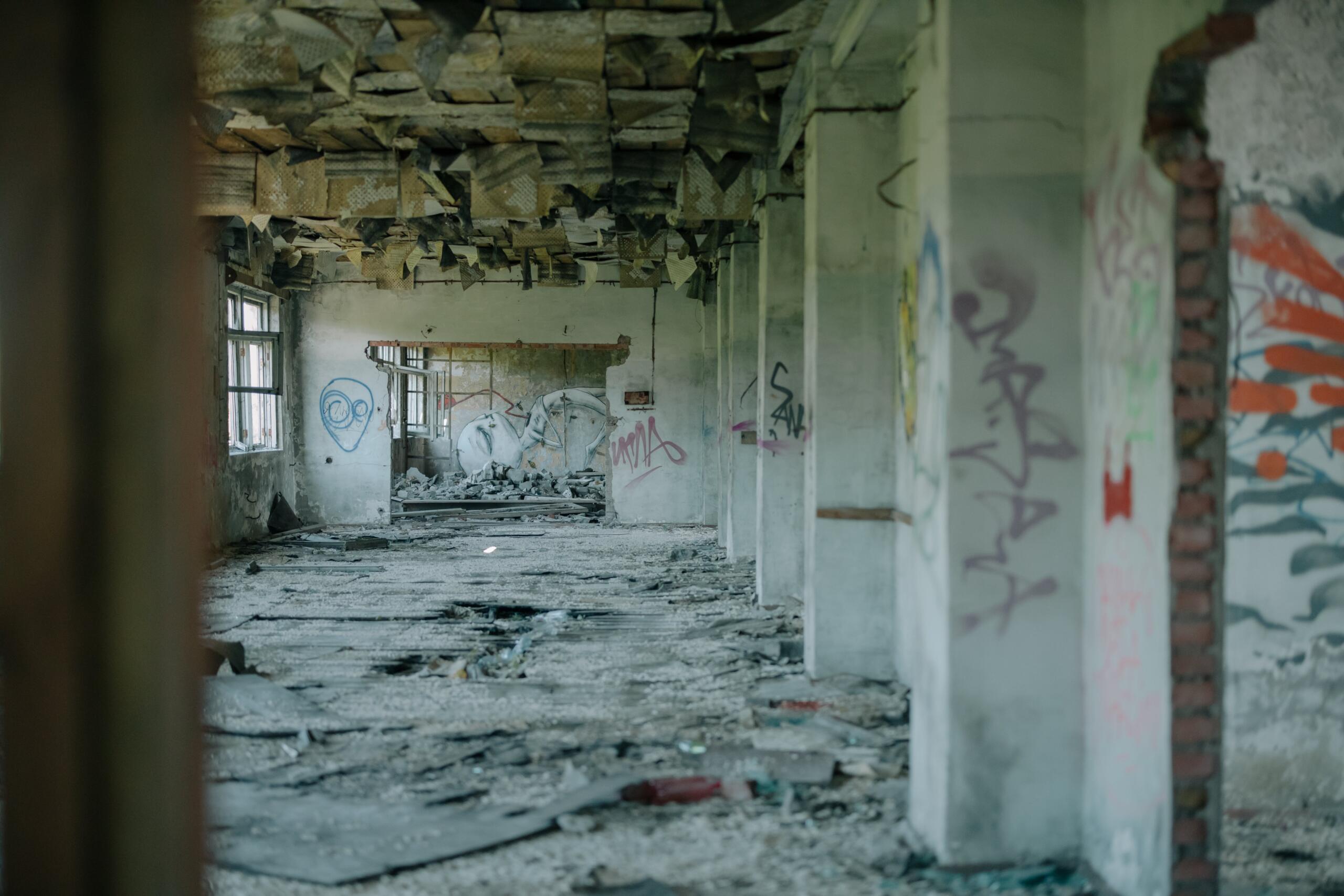 Ein stark verwüsteter Betonrohbau von innen, beschmiert mit Graffiti