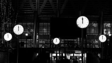 Mehrere Uhren, die kurz vor zwölf zeigen, in schwarz-weiß